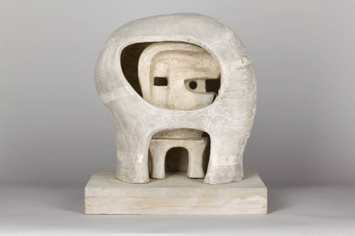 A studio photo of a small plaster sculptural model of an abstract helmeted head.