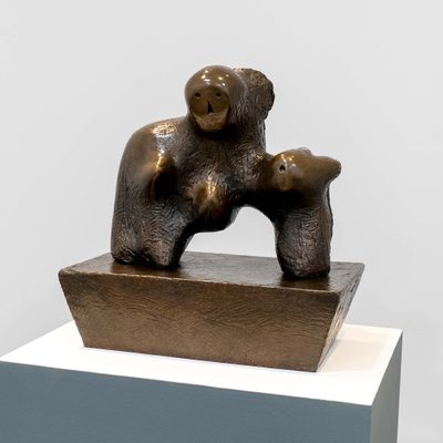 A bronze semi-abstract sculpture with shapes resembling two faces and a breast, sat on a bronze plinth.