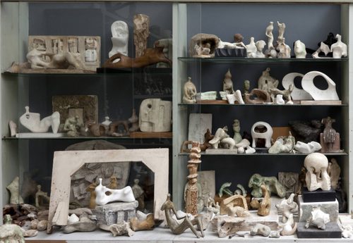 Shelves inside Henry Moore's Bourne Maquette Studio displaying plaster sculpture models and found objects.