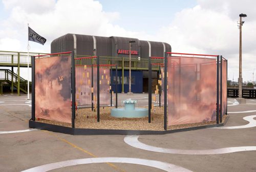 A park-like sculpture, with a small fountain and fence-like screening, displayed on a concrete rooftop space.