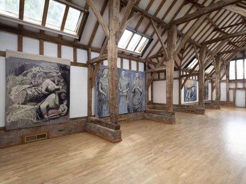 A wide shot of one wall in the Aisled Barn at Henry Moore Studios & Gardens, four of Moore's tapestries (based on his drawings) are visible