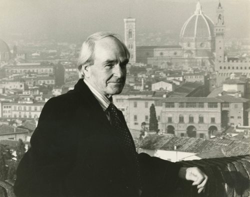A black and white photo of Henry Moore in 1971. He is standing at the Forte di Belvedere in Florence, Italy with a view of the city and the cathedral (Duomo) behind him.