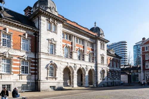 The entrance to Chelsea College of Arts, an impressive, three-storey stone and brick building with a large courtyard in front.