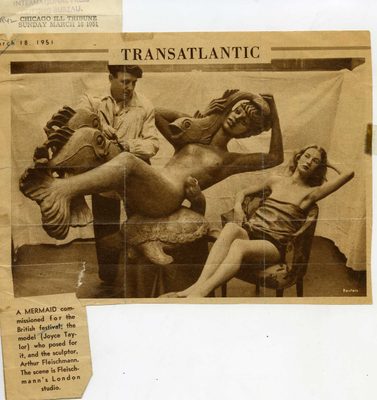 Newspaper cutting with the heading 'Transatlantic' and a photo showing a man at work on a mermaid sculpture, while a female model poses alongside.