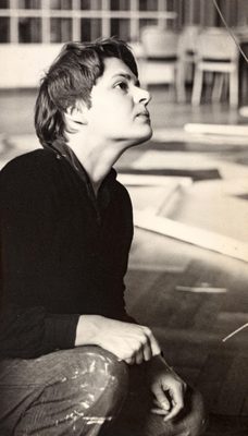 Black and white portrait photo of a young woman with short, dark hair, looking up and away from the camera.