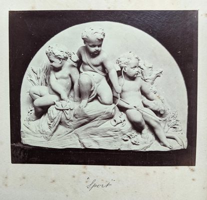 Black and white photo of a sculpture of three cherubs.