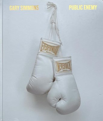 Cover of the book 'Gary Simmons : public enemy', showing a pari of white boxing gloves hung on a white wall.