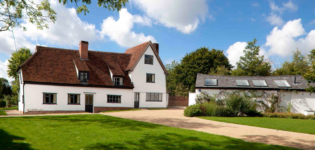 A path leads to Hoglands, a white painted former farmhouse with a red tiled roof, and the smaller Top Studio building.