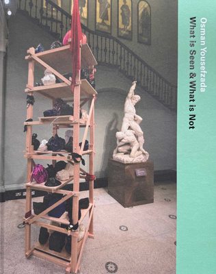 Cover of the book Osaman Yousefzada: What is Seen & What is Not. The cover features a photo of a classical Greek marble statue next to a sculpture made from wooden shelving with objects wrapped in plastic on it.