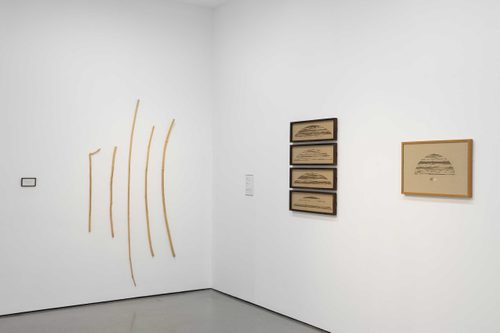 Wooden works by Roger Ackling hung in a white-walled gallery space.