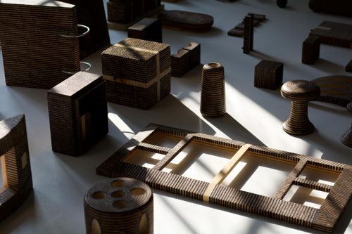 A collection of wooden objects that have all been 'decorated' with different patterns of black lines, burnt by the sun.